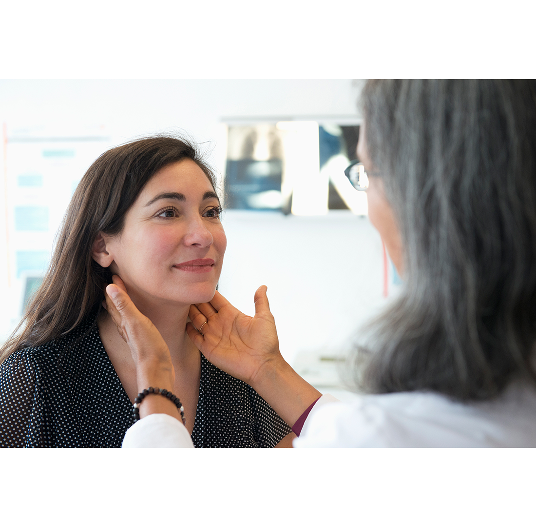 doctor touching woman's throat