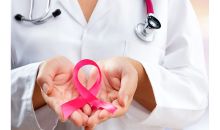 doctor holding pink ribbon for breast cancer awareness