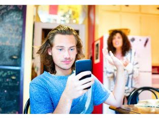 Male teenager ignoring scolding mom with mobile phone