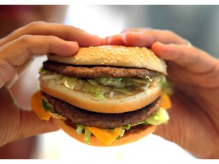 hands holding fast food burger