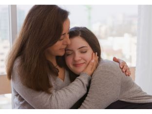 mom hugging teen daughter gray sweaters