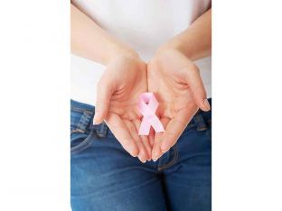 woman in jeans holding pink ribbon