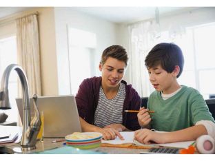 Teen boy assisting brother in doing homework