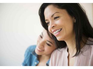 mother and teen daughter smiling together
