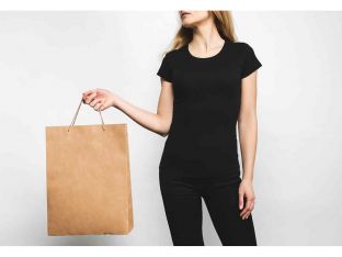 young woman in blank black t-shirt on white with shopping bag