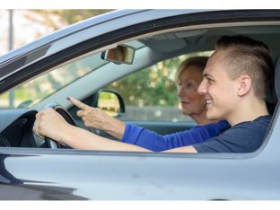 teen boy practicing driving with mom