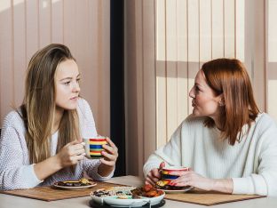Mother and daughter talking while having breakfast at home
