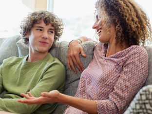 mom and teen son talking on couch