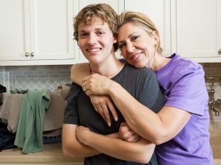 portrait of mother and teen son in laundry room