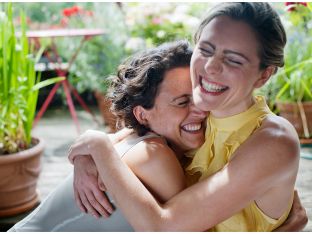 two women happily hugging