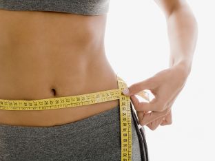 fit woman measuring waist