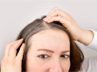 woman looking at her gray roots
