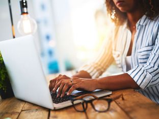 woman working on laptop on wooden table