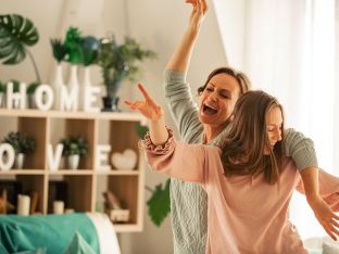 mom and daughter dancing and singing together