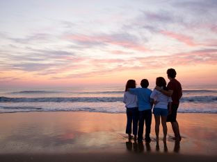 anonymous family standing on beach