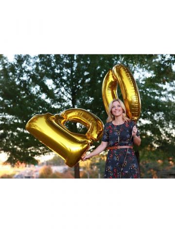 Amy Reinecke holding "100" Balloons