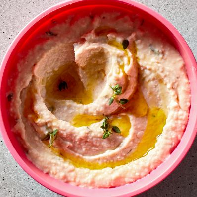 white bean dip in pink bowl
