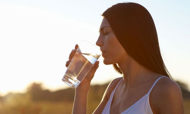 woman drinking water outdoors