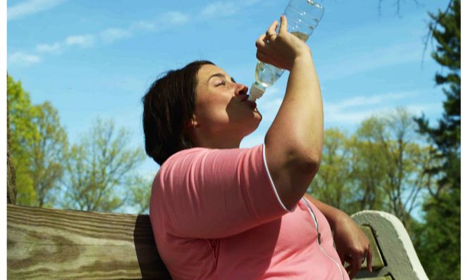woman drinking water outdoors