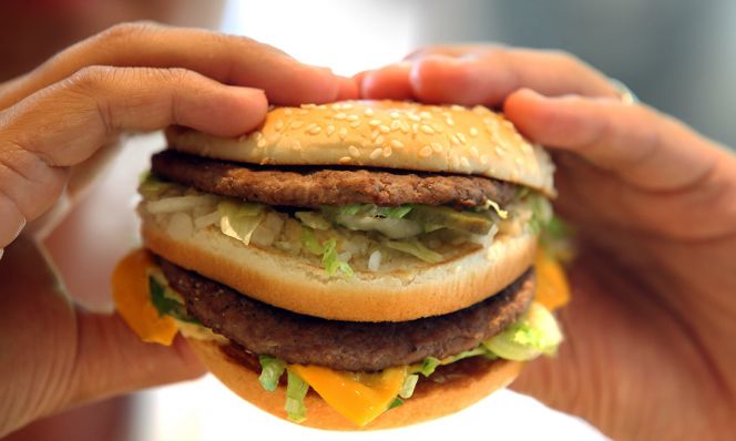 hands holding fast food burger