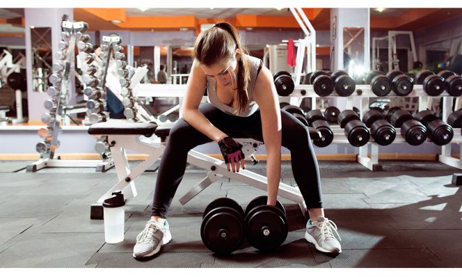 woman lifting heavy dumbbells