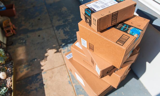 stack of amazon boxes on doorstep