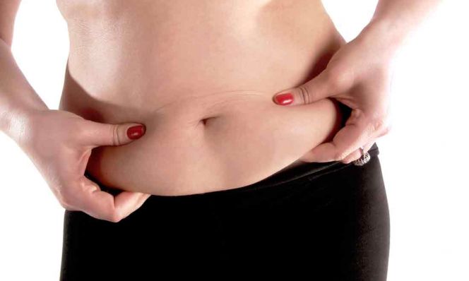 woman holding fat on stomach