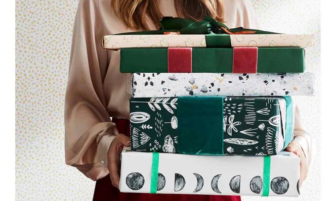 woman with a stack of wrapped christmas presents