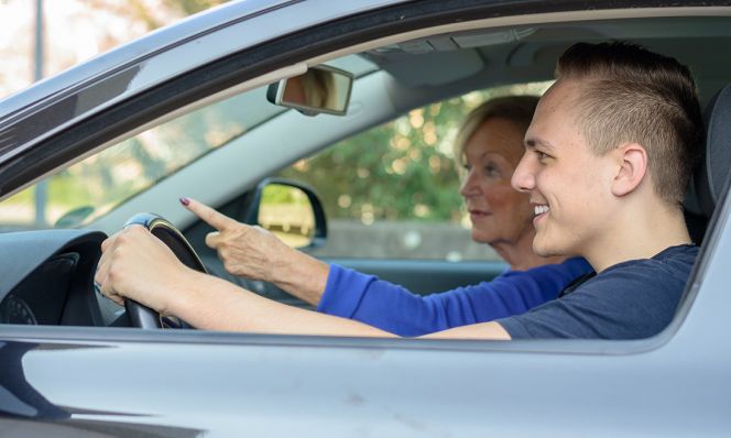 teen boy practicing driving with mom