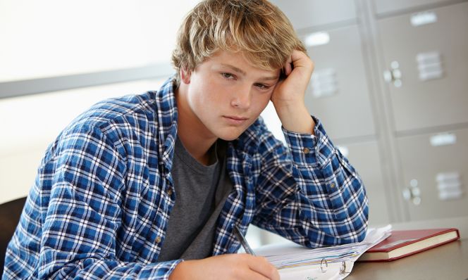 Teen boy looking bored/sleepy in class