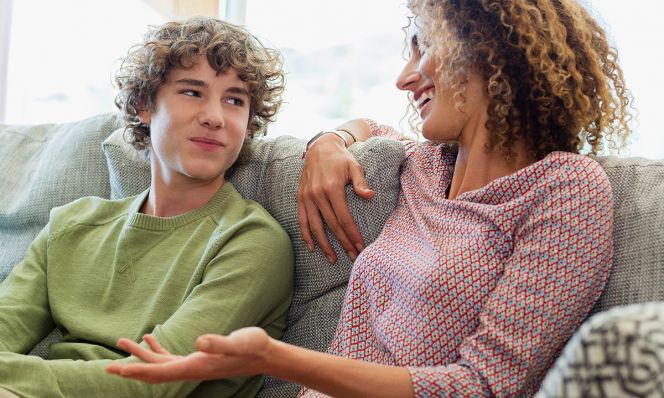mom and teen son talking on couch