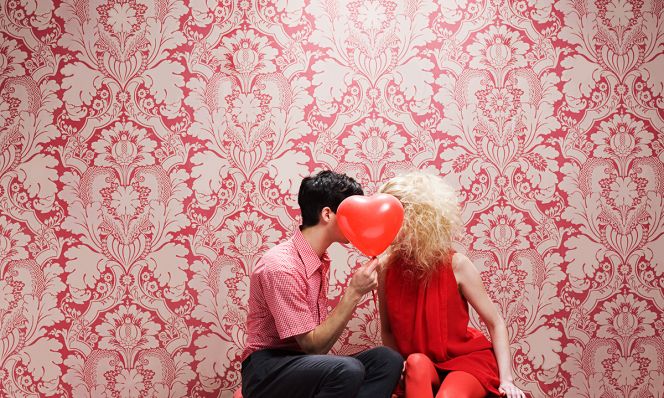 young couple behind a heart-shaped balloon