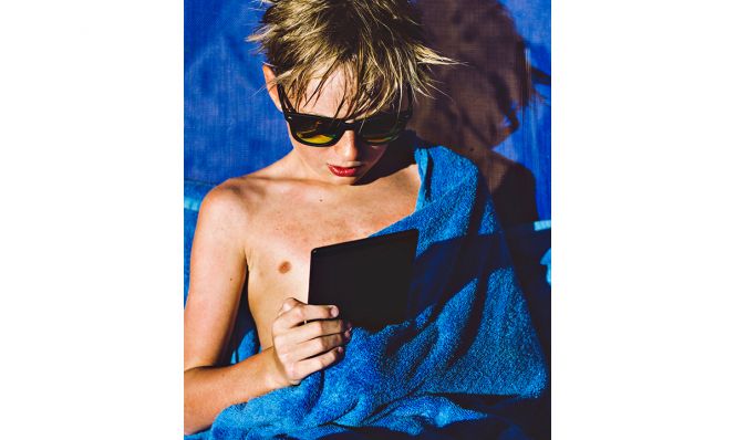 boy reading on amazon kindle paperwhite